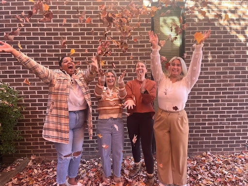 La’Bri Williams, Christine McLaughlin, Megan Boyd, and Colette McDonnell throwing leaves.